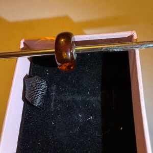 Trollbead reddish amber with gold flecks and dark flecks